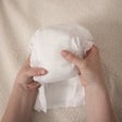 Ultra Soft diaper held in hand, folded white disposable diaper