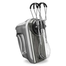 Hand mixer on its side with multiple wire beaters and black speed controls.