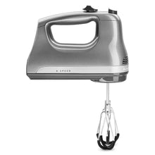 Hand mixer side view with 6-speed label and two wire beaters installed.