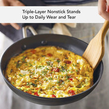 Black nonstick fry pan with cooked food and a wooden spatula