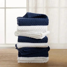 Cotton kitchen towel set stacked in navy, white, and dark blue, waffle texture