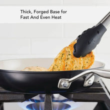 Ceramic nonstick fry pan on stovetop with food and metal handle