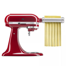 KitchenAid® stand mixer with red pasta cutter attachment, showing yellow pasta ribbons