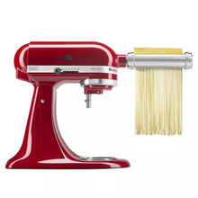 KitchenAid® stand mixer with red pasta cutter attachment, dispensing long yellow pasta strands