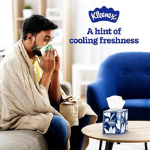 Kleenex cooling facial tissues box on table, tissue used by seated person