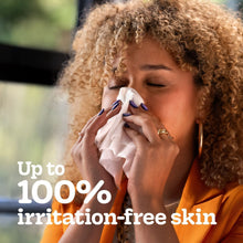 Kleenex facial tissues in use, tissue held to nose by person