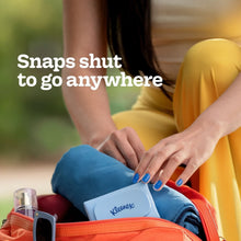 Kleenex tissues case in open orange bag, hands holding case
