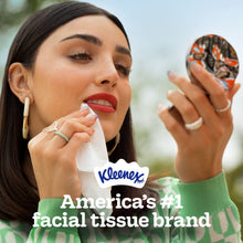 Kleenex facial tissue held to cheek by person