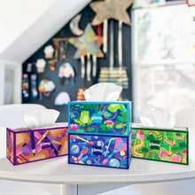 Three Kleenex tissue boxes with colorful patterns and open white tissues on shelves
