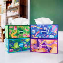 Facial tissue boxes set with colorful fronts, white tissues protruding from two boxes