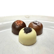 Chocolate truffles on plate: dark brown and cream centers with toppings