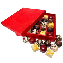Chocolate gift box with red lid, assorted truffles spilling from open tray
