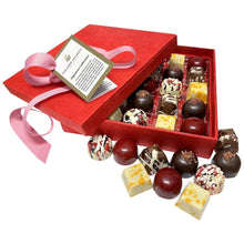 Chocolate gift box with red lid, assorted truffles in open tray, tied ribbon
