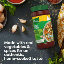 Chicken bouillon jar with garlic cloves and herbs around it