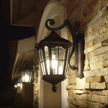 Outdoor wall lantern on exterior wall, black frame with clear glass panels