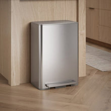 Kohler 45L stainless steel step trash can with closed lid, shown beside kitchen cabinetry
