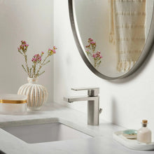 Oval framed bathroom mirror with silver-gray border on wall