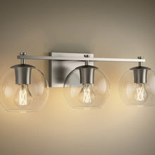 Three-light wall sconce with clear globe glass shades and brushed nickel crossbar