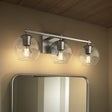 Three-light wall sconce with clear globe glass shades and brushed metal bar