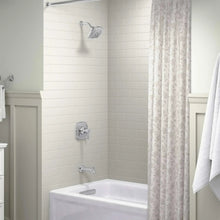 Chrome shower trim with showerhead and mixing valve on tiled wall