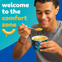 Ranch mac and cheese cup with spoon held by a smiling person