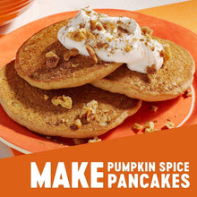 Pumpkin spice pancakes on a plate with whipped topping and chopped nuts