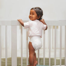 Kudos diaper on a toddler standing and holding a crib rail