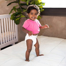 Kudos diaper worn by a toddler standing on a bed