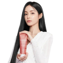 Protein bonding hair treatment bottle, violet lily, held in hands