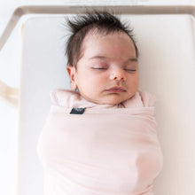 Pink baby sleep bag swaddler swaddling infant’s arms near the neck
