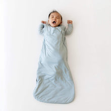 Light blue baby sleep sack worn by an infant, arms out