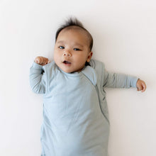 Light blue baby sleep sack worn by an infant, front close-up