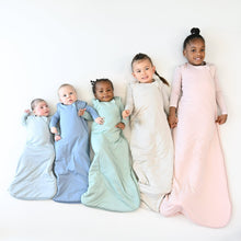 Baby sleep sacks in assorted colors worn by four children
