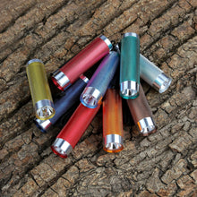 Multicolor LED flashlight set with silver heads lying on tree bark