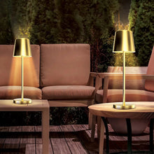 Two gold LED patio touch lamps on outdoor side table with bases