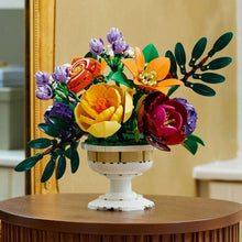 LEGO flower arrangement centerpiece on a white pedestal stand with large orange and dark red flowers