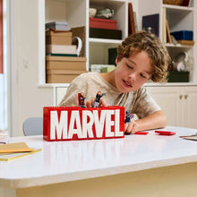 Child assembling a LEGO Marvel set on a table beside the box