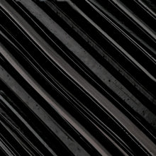 Black mascara tube close-up with diagonal ridges and reflective highlights