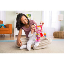 Infant clip-on plush doll toy with pink hood, colorful dress, and dangling rattle