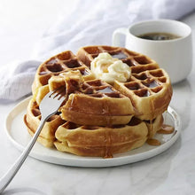 Unsalted butter cubes on Belgian waffles on a plate, with a fork