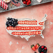 White porcelain U.S. map platter holding layered berry bars with frosting.