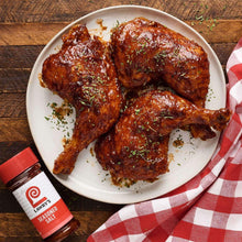 Plate of seasoned chicken with Lawry's seasoned salt bottle at the side