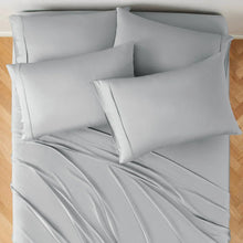 Light gray bed sheet set with pillow shams and pillowcases on the mattress