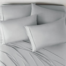 Bamboo rayon sheet set on bed with three light-gray pillowcases