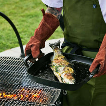 Square grill basket holding sliced fish on a black perforated tray
