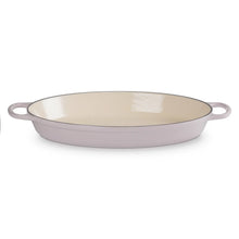 Cast iron oval baker with side handles, cream interior and light purple exterior