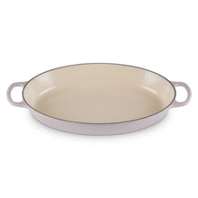 Oval enamel cast iron baker with cream interior, pinkish rim, loop handles