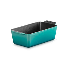 Cast iron loaf pan in teal with black interior, side handles and fitted rim.