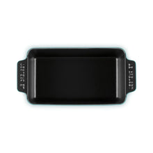 Cast iron loaf pan in teal with black interior, top-down view showing rim and handles.