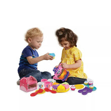 Musical tea party toy set with pink teapot, cups, plates, and cupcake carry case in use